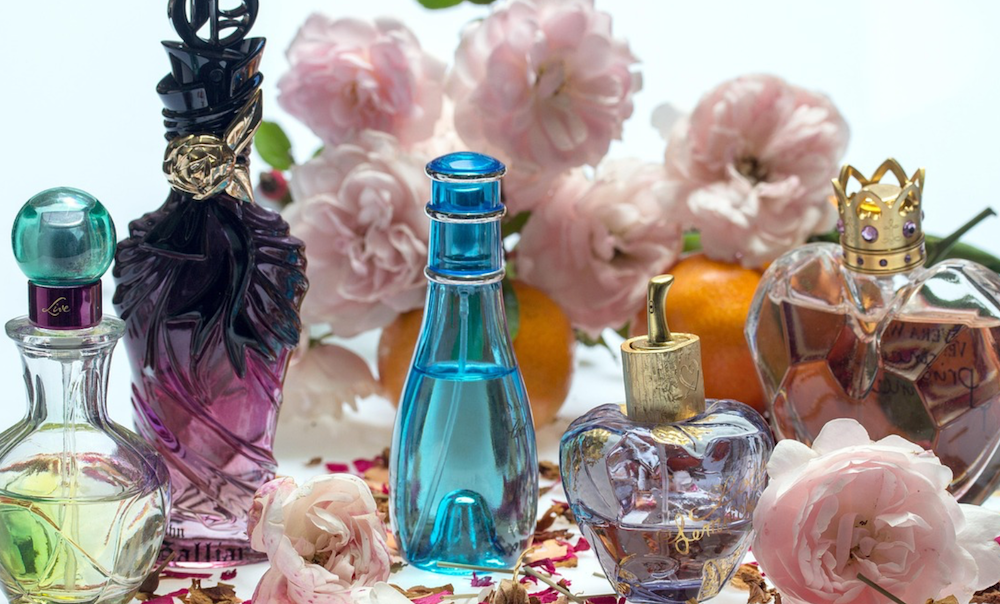 nameless perfumes on a table with pink roses