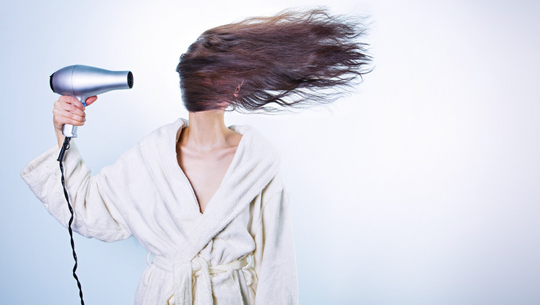 woman blowdrying her hair 